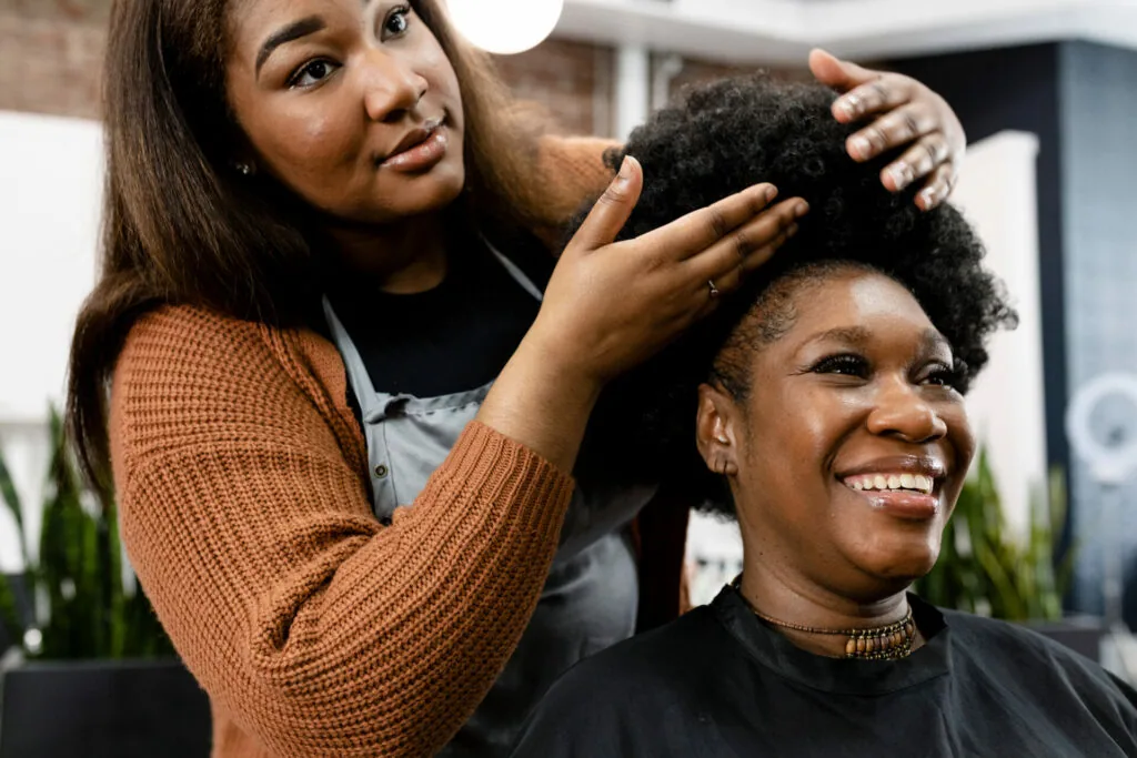 Stylist touching client's hair during salon appointment